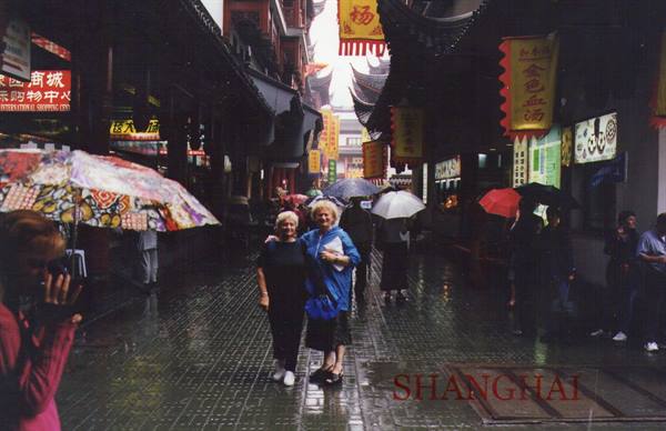 Two women with umbrella in the rain on a Shanghai pedestrian street