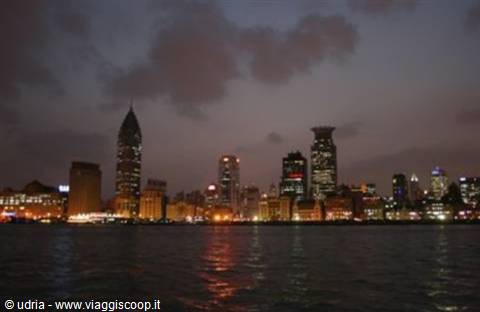 Illuminated Shanghai skyscrapers reflected on the dark Huangpu river water
