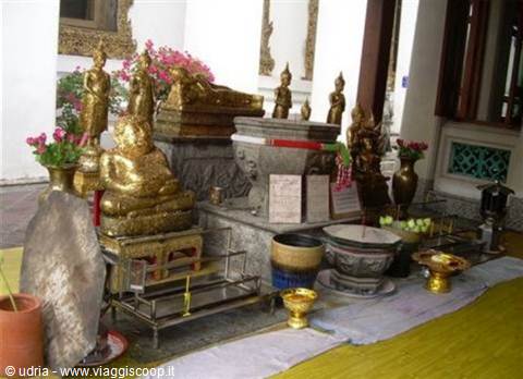 Gilded Buddha statues and offerings inside a Thai temple