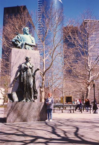 Tourist beside the bronze Verrazzano statue in Battery Park, New York
