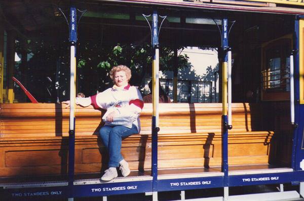 Woman sitting on the wooden bench of a vintage cable car