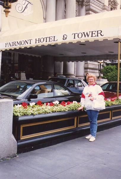 Smiling woman beside flowers outside the Fairmont Hotel & Tower