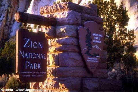 Wooden and stone entrance sign at Zion National Park in golden light