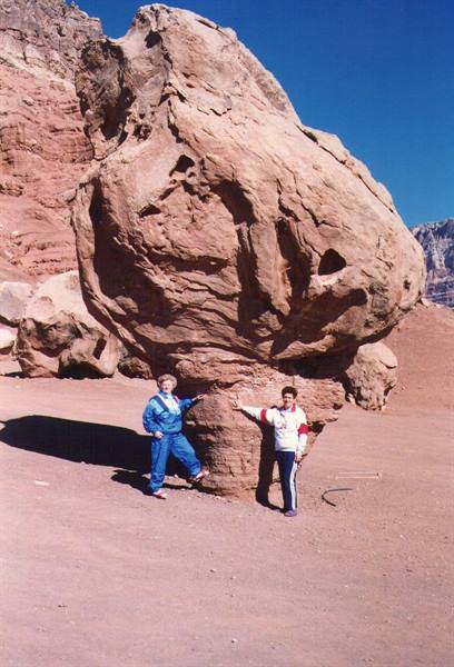 Tourists beside a large red sandstone rock, Timna