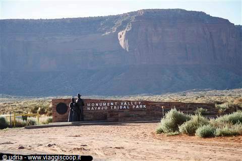 Stone entrance sign of Monument Valley Navajo Tribal Park, red mesa behind