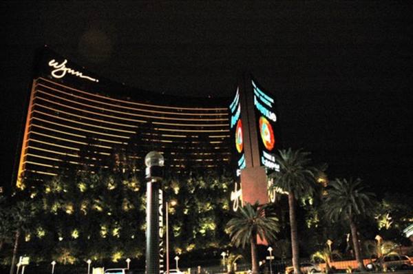 Wynn hotel lit up at night in Las Vegas, palm trees and neon signs