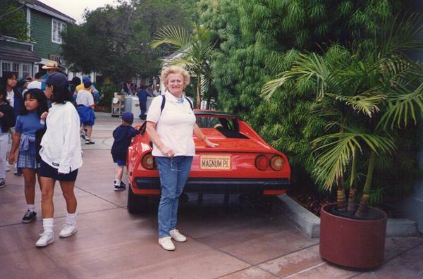 Woman posing beside Magnum P.I. red Ferrari at Universal Studios