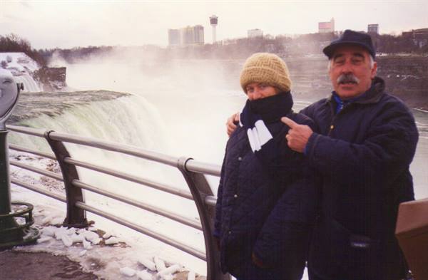 Couple in front of Niagara Falls in winter, snow and mist around