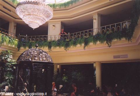 Crystal chandelier above an atrium with iron cage and green plants