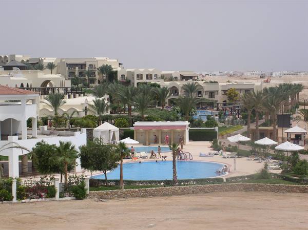 Blue pool with white umbrellas and palm trees at Sharm el-Sheikh resort