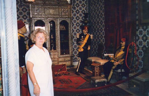 Tourist beside wax figures of Ottoman officers in an inlaid wood palace room