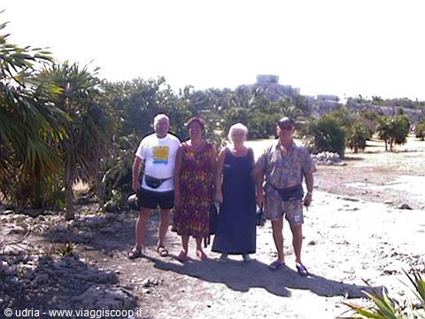 Four tourists posing on the path, behind the Mayan ruins of Tulum