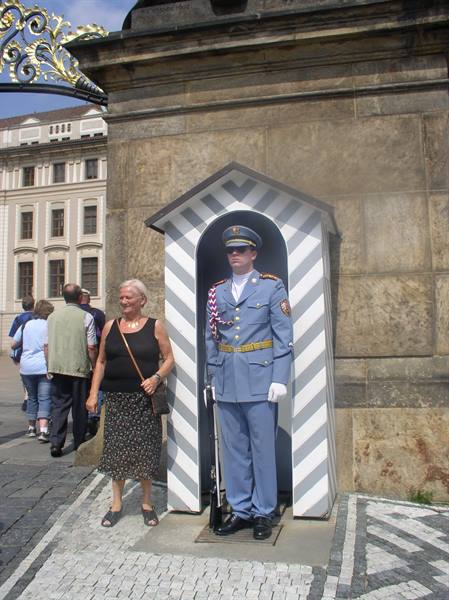 Blue-uniformed castle guard at sentry box, Prague Castle, tourist nearby