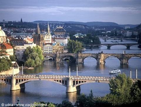 Charles Bridge and bridges over the Vltava in Prague, evening light, boat on river