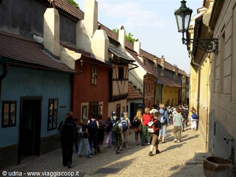 Backpackers walking along the cobblestone lane of colourful cottages, Golden Lane, Prague