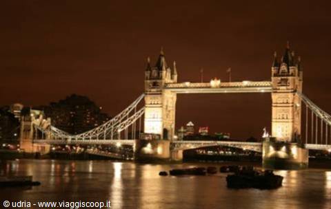 London's Tower Bridge lit up at night, reflecting on the Thames