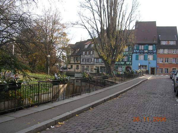 Colorful half-timbered houses along the canal, cobbled street in Colmar
