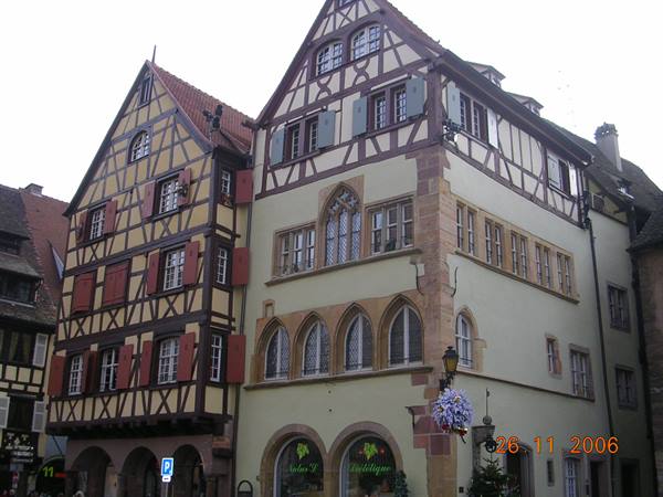 Half-timbered houses in Colmar, brown beams, red shutters, grey daylight