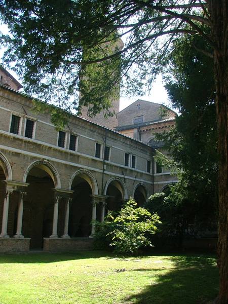 Romanesque cloister arcades and brick bell tower, shaded lawn with backlit trees