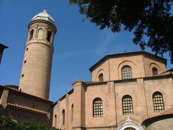 Cylindrical brick bell tower and Basilica of San Vitale in Ravenna under blue sky