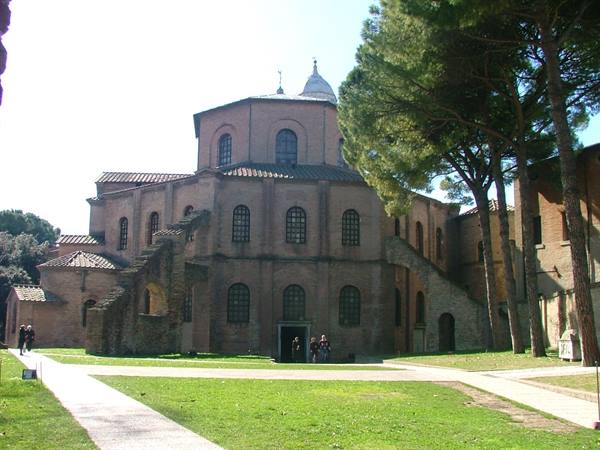 Basilica of San Vitale in Ravenna, ancient brick among pines and green lawn