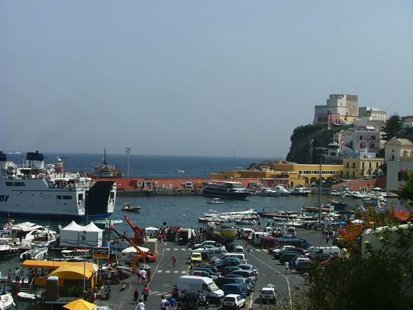Ferry moored at Ponza harbour, boats and cars along the quay