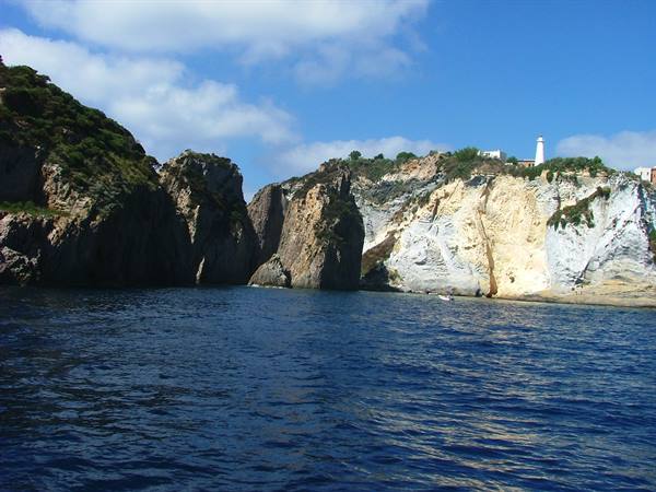 White cliffs rising over blue sea, lighthouse on top, Ponza