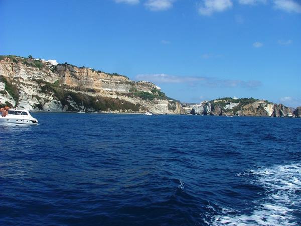 Boat wake with white cliffs of Ponza and houses above the sea