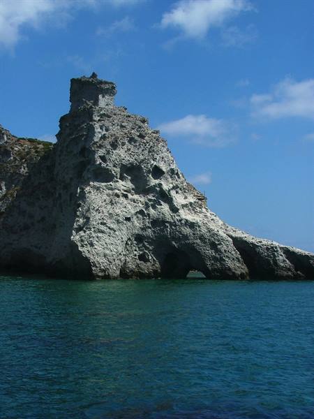 White limestone rock with natural arch over turquoise green sea