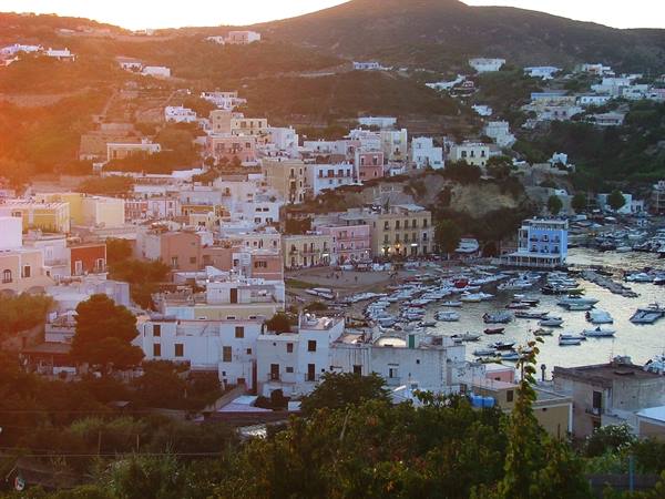 Ponza harbour at dusk, boats moored among pastel-colored houses