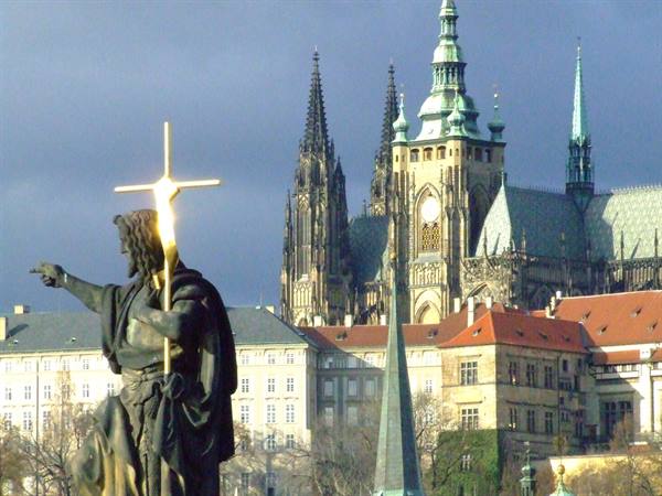 Statue on Charles Bridge and,in the background,the majestic St Vitus Cathedral