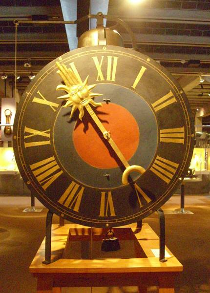 Antique clock with golden sun and Roman numerals, museum display