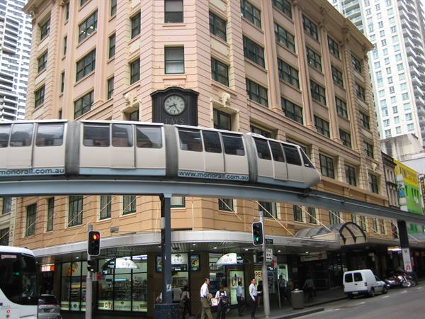 Elevated monorail passes a heritage clock building in Sydney