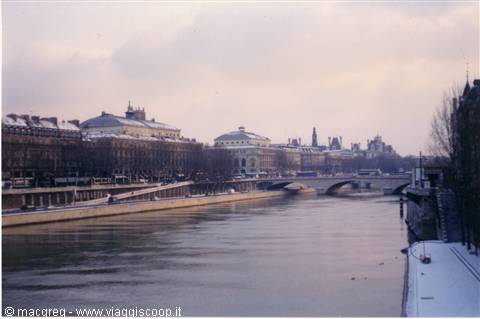 Snowy Seine river in Paris with bridge and Haussmann buildings under snow