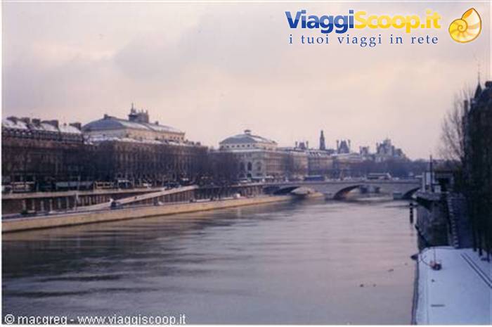 Snowy Seine river in Paris with bridge and Haussmann buildings under snow