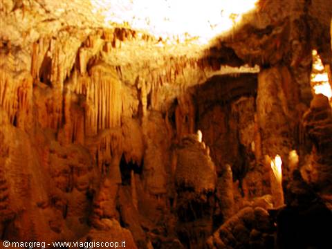 Postojna Cave, limestone stalactites and columns lit by warm light
