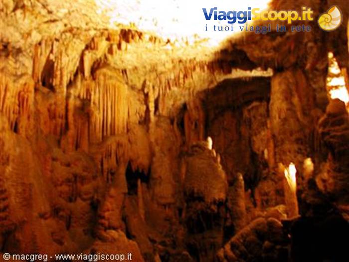 Postojna Cave, limestone stalactites and columns lit by warm light