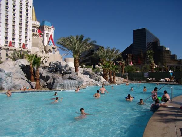 Excalibur pool in Las Vegas: tourists swim among palm trees and artificial rocks