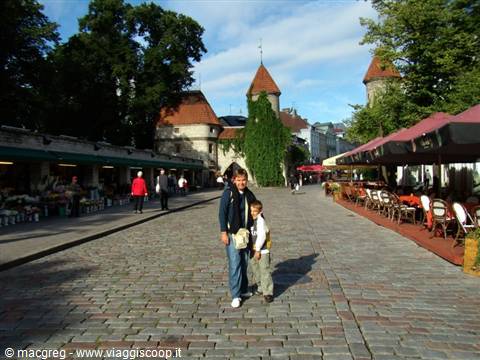 Child and adult posing on cobblestones in front of Viru medieval gate, Tallinn