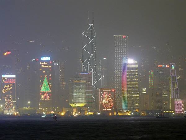 Illuminated skyscrapers with Christmas lights over the harbour, misty night