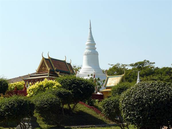 White stupa and golden pavilions among green trees, Phnom Penh
