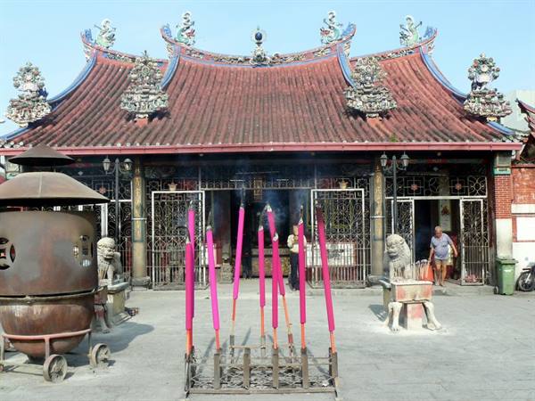 Pink incense sticks before Cheng Hoon Teng temple, ornate tiled roofs and smoke