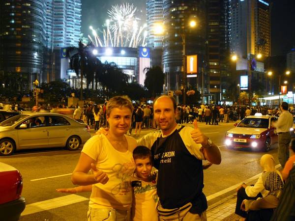 Family thumbs-up under fireworks at the Petronas Towers, Kuala Lumpur