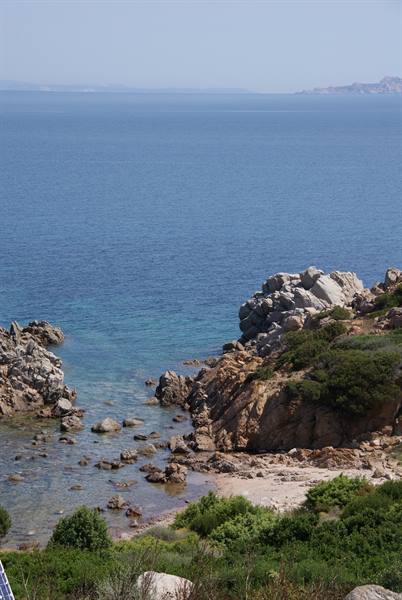 Granite rocks and Mediterranean scrub over clear turquoise sea, Costa Smeralda
