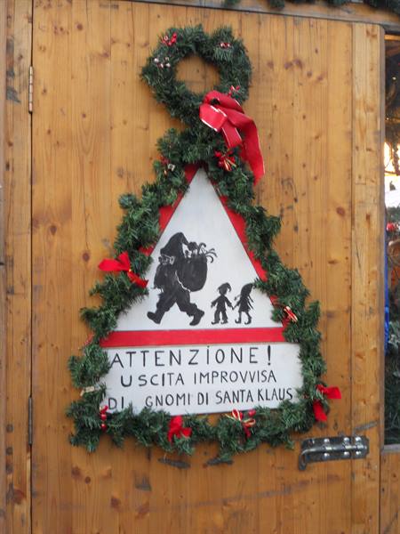 Christmas warning sign on a wooden door: Santa Klaus's elves may suddenly appear