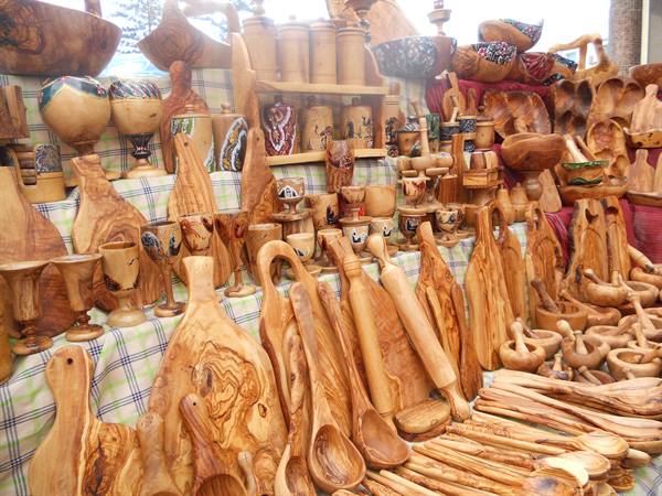 Market stall displaying olive wood boards, spoons and goblets for sale