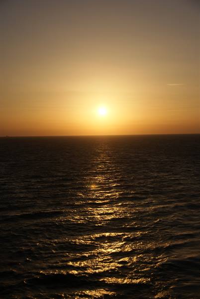 Low sun over open sea, golden reflection on dark waves