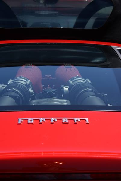 Red Ferrari rear with its engine visible beneath the rear window