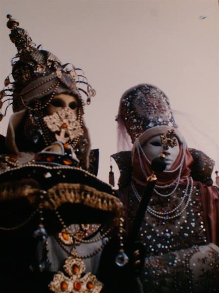 Masks in golden costumes and pearls at Venice Carnival