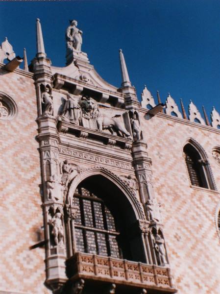 Doge's Palace in Venice: Gothic marble portal with winged lion and statues in sunlight
